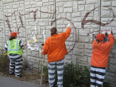 3 inmates painting over graffiti